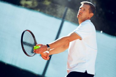 Genç proffesional tenis oyuncusu servis yapıyor.