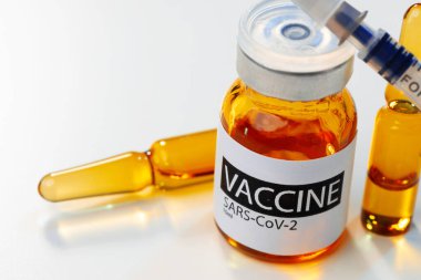 Sars-cov-2 aşı şişesi ve şırınga beyaz masa üzerinde