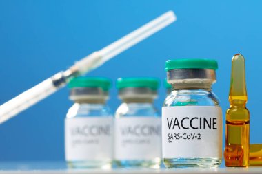 Sars-cov-2 aşı şişesi ve şırınga beyaz masa üzerinde
