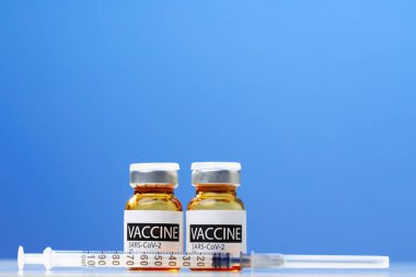 Sars-cov-2 aşı şişesi ve şırınga beyaz masa üzerinde