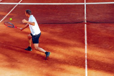 Tenis kortunda oynayan bir adamın arka görünüşü