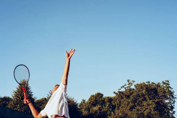 Genç proffesional tenis oyuncusu servis yapıyor.