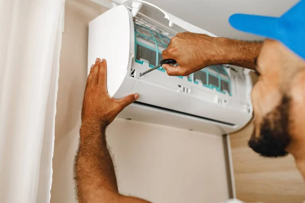 Reparador profesional instalando aire acondicionado en una habitación — Foto de Stock