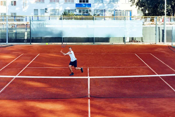 Mann spielt Tennis auf Sandplatz-Sicht aus der Ferne — Stockfoto
