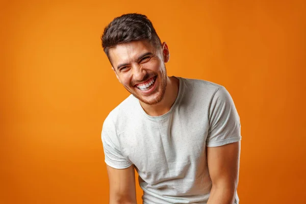 Young positive european man standing in blank white shirt laughing