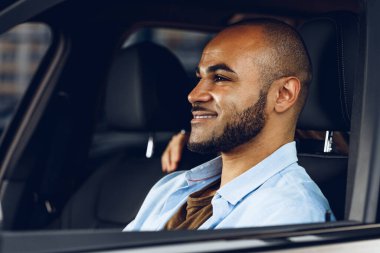Bir arabada oturan Afrikalı Amerikalı erkek sürücü.