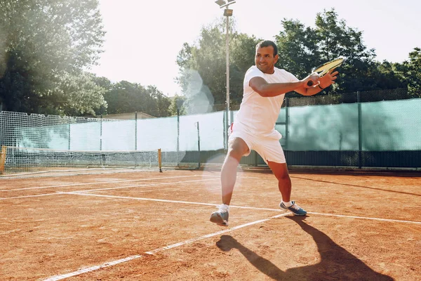 Здоровый человек играет в теннис на теннисном поле — стоковое фото