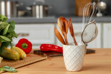 Mutfak takımları mutfak masasındaki bardakta.