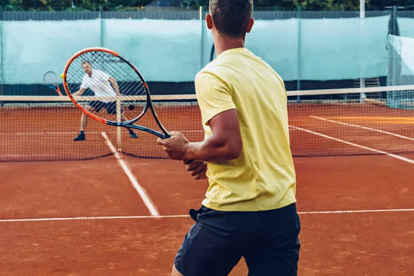 Zwei Männer spielen Tennis auf Sandplatz — Stockfoto