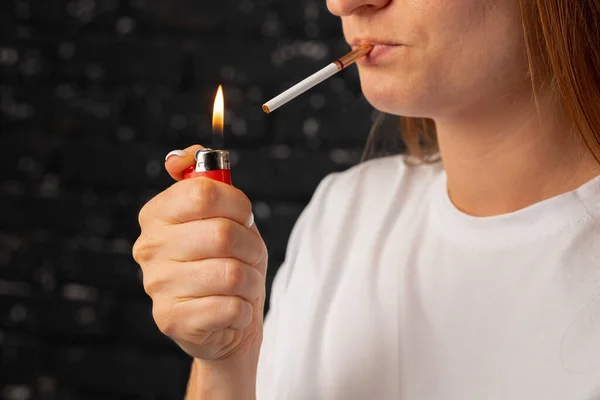 Onherkenbare vrouw steekt sigaret aan met vuuraansteker — Stockfoto