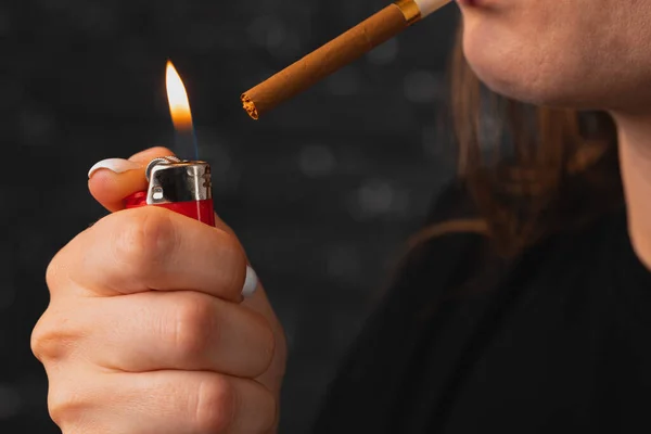Neznámá žena zapaluje cigaretu zapalovačem — Stock fotografie