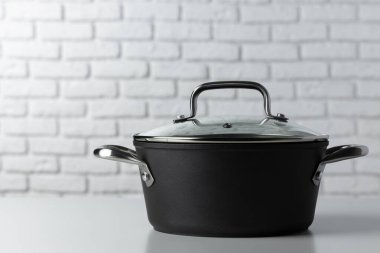 Beyaz tuğlalı duvara karşı pişirme kabı