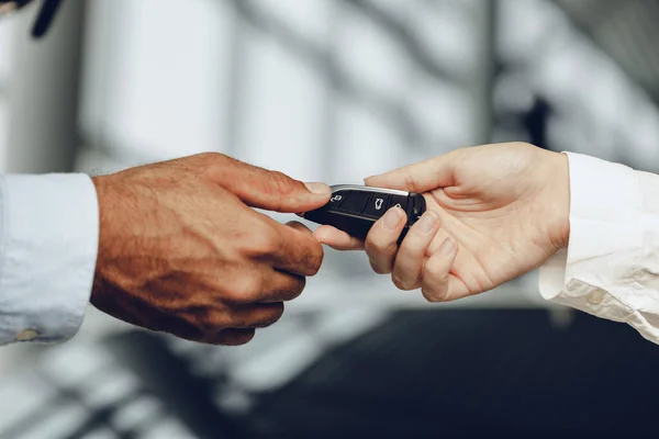 Bilförsäljare ger nycklar till en kund närbild — Stockfoto