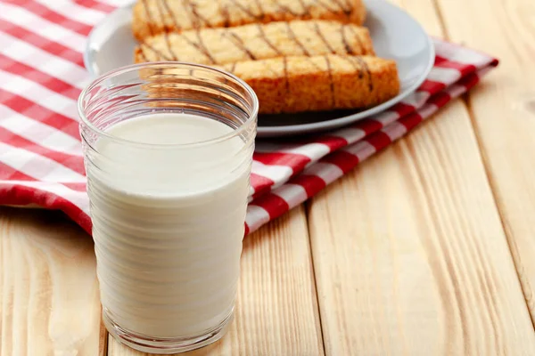 Oat cookies and glass of milk on wooden table — Stock Photo, Image