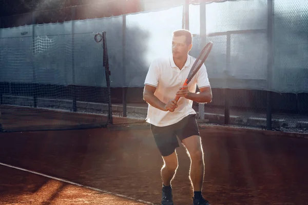 Jeune homme joue au tennis en plein air sur le court de tennis le matin — Photo