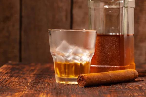 Un verre de whisky et un cigare sur une table en bois — Photo