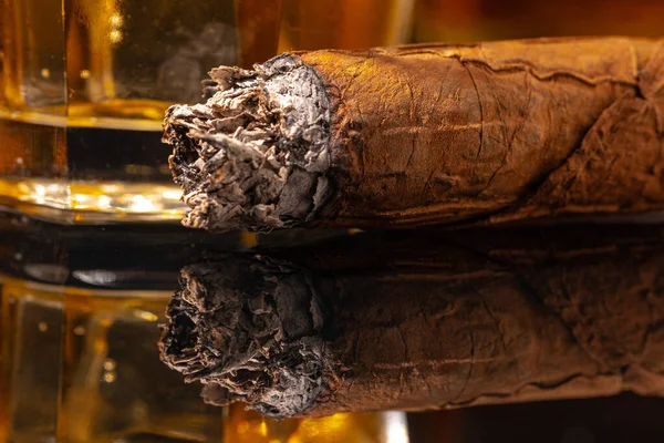 Szklanka whisky i zapalone cygaro na czarnym tle — Zdjęcie stockowe