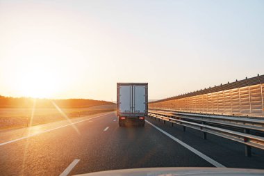 Kamyon gün doğumunda otoyolda gidiyor.