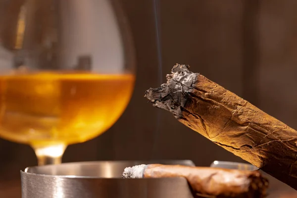 Verre de whisky et cigare allumé dans un plateau de cendres — Photo