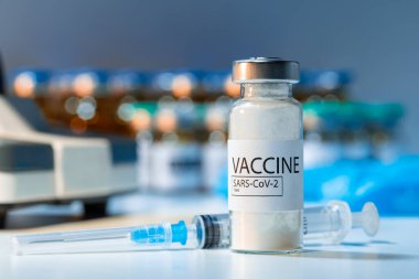 Laboratuar masasında şırınga olan Covid-19 aşı şişesi.