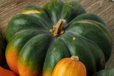 Kahverengi ahşap arka planda bir yeşil balkabağı