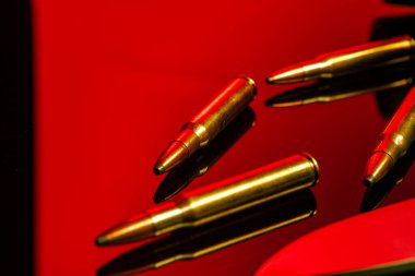 Kırmızı ışıkta cam zemin üzerinde tüfek fişekleri