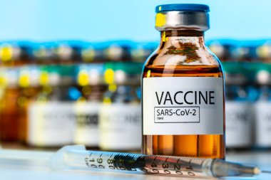 Laboratuar masasında şırınga olan Covid-19 aşı şişesi.