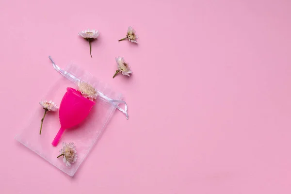 Copo menstrual com flores no fundo rosa — Fotografia de Stock