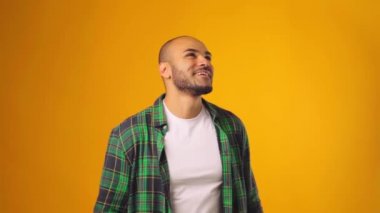 Mutlu Afrikalı Amerikalı adam sarı arka plana karşı başarıyı kutluyor