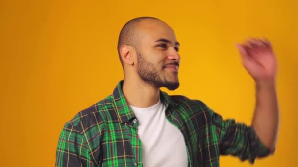 Joyeux modèle homme afro-américain regardant de côté et souriant sur fond jaune — Video