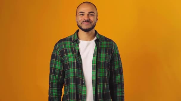 黄色の背景と笑みを浮かべて立ってハンサムなアフリカ系アメリカ人男性 — ストック動画
