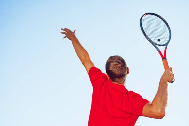 Genç proffesional tenis oyuncusu servis yapıyor.