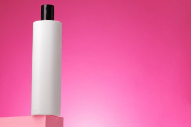 Pembe arka planda boş beyaz kozmetik kabı