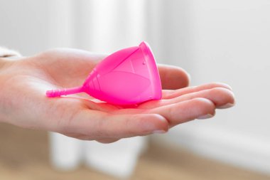 Adet bardağını elinde tutan kadın. Yakından.