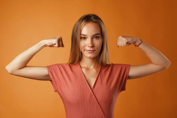 Lustig ung blond kvinna visar hur starka hennes händer är. — Stockfoto