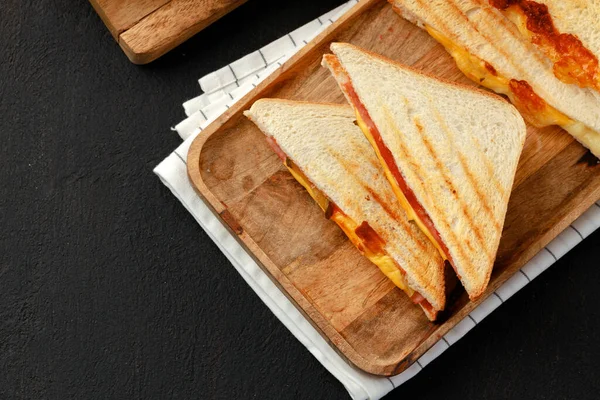 Sandwiches cortados en mitades en tabla de cortar de madera con servilleta — Foto de Stock