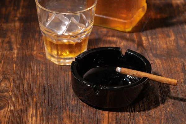 Glass of whisky and lighted cigar in an ash tray — Stock Photo, Image