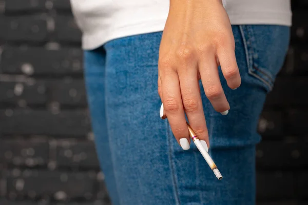 Female hand holding lighted cigarette close up — Stock Photo, Image