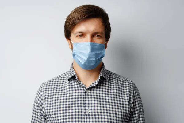 Man bär hygienisk mask mot grå bakgrund — Stockfoto