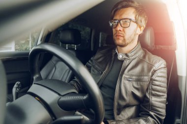 Arabada oturan kendinden emin genç adam.