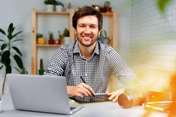 Hombre sonriente fotógrafo o retoque de trabajo desde casa —  Fotos de Stock
