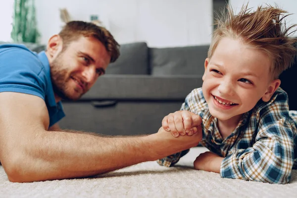 아버지 와아들 팔은 집에서 카펫 위에서 레슬링을 한다 — 스톡 사진