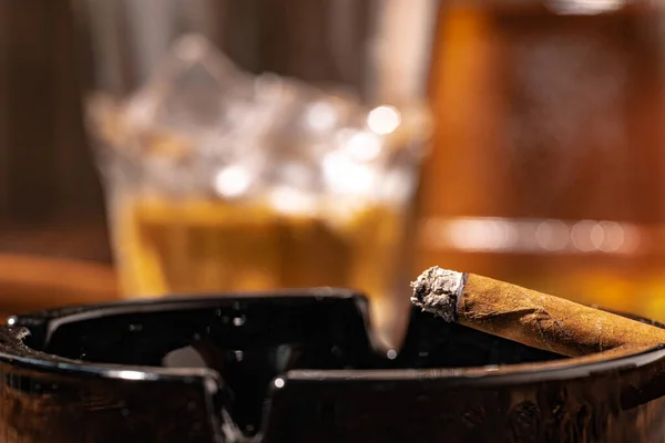 Verre de whisky et cigare allumé dans un plateau de cendres — Photo