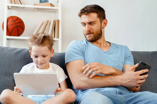 Pai preocupado espreitando para o que seu filho está assistindo no tablet digital — Fotografia de Stock