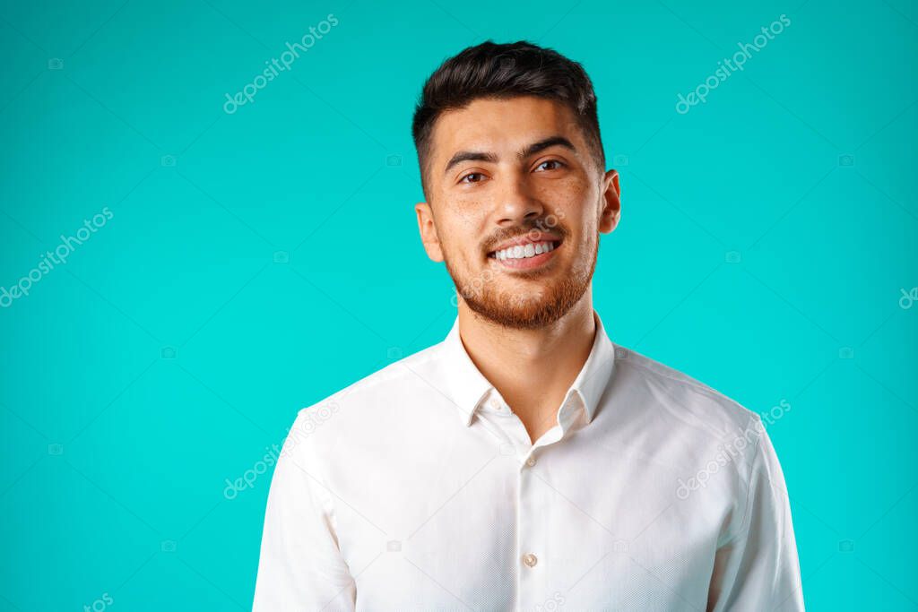 Young positive man in white casual shirt standing with happy smile