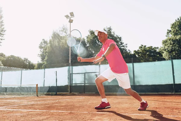 Mann mittleren Alters spielt Tennis im Freien — Stockfoto