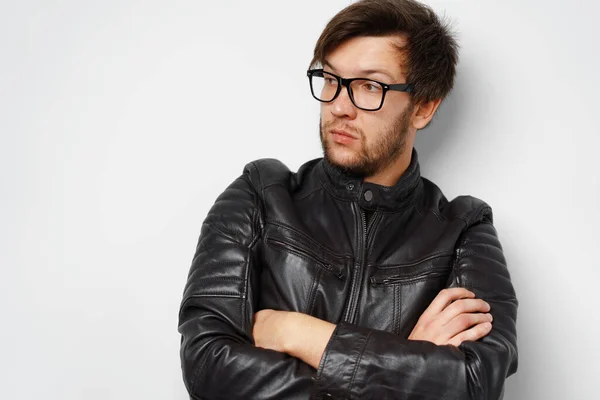 Porträt eines jungen Mannes mit Brille und schwarzer Lederjacke auf grauem Hintergrund — Stockfoto