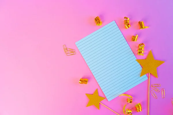 Notitieblok papier met gouden linten en gouden sterren op roze achtergrond — Stockfoto