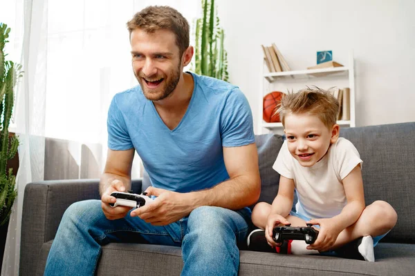 Vader en zijn zoontje spelen thuis videospelletjes. — Stockfoto