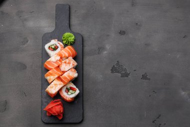 Siyah arka planda somon ve karidesli suşi rulosunun üst görüntüsü
